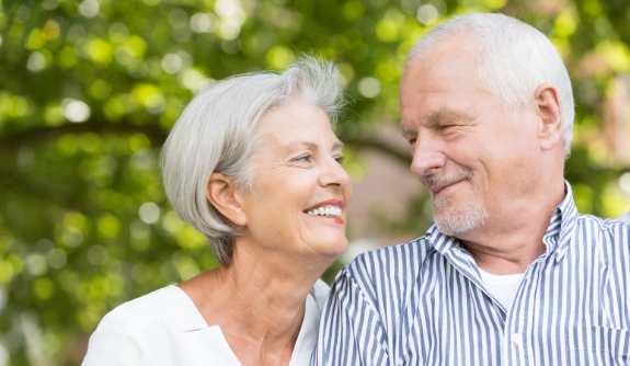 Man and woman enjoying healthy smiles after restorative dentistry