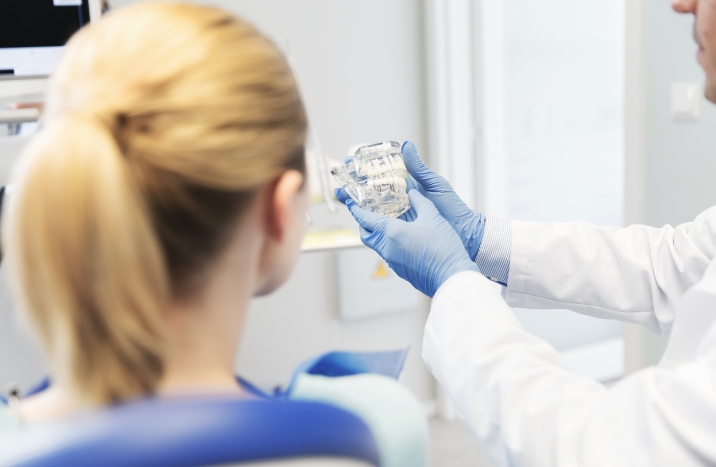 Dentist and patient looking at smile model during preventive dentistry