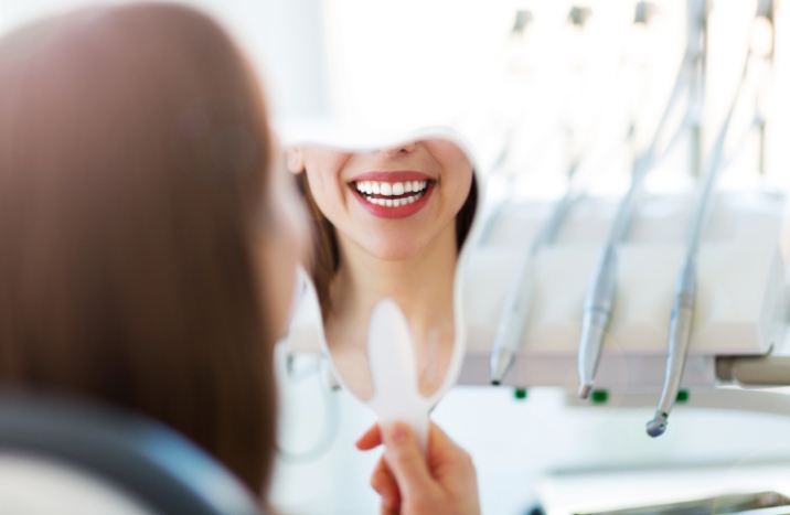 Woman looking at her smile after cosmetic dentistry