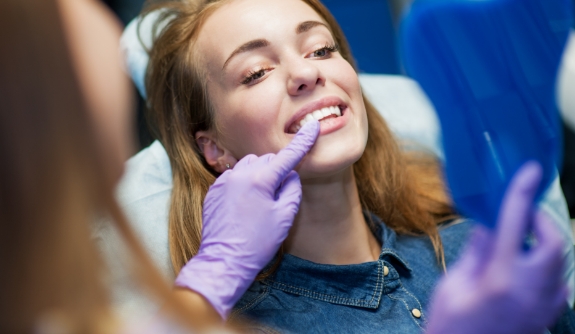 Dentist examining dental patient's smile during gum disease treatment