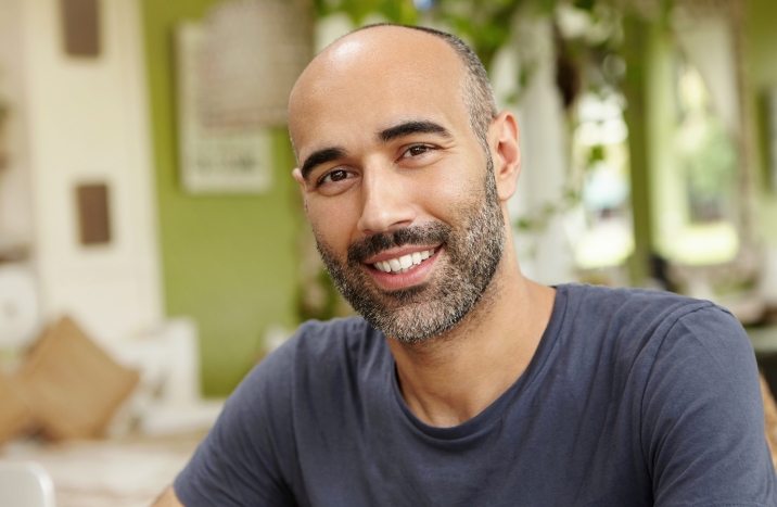 Man with flawless smile after dental implant tooth replacement