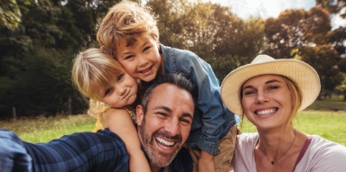 Family of four smiling after visiting their dentist in Saratoga Springs New York