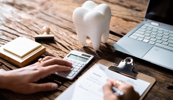 Dentist calculating dental insurance coverage