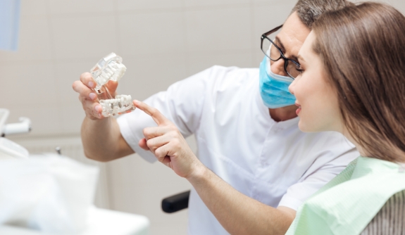 Dentist and dental patient looking at smile model